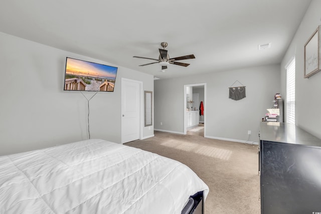 bedroom with ceiling fan, light carpet, and ensuite bath