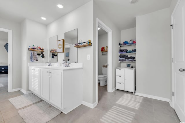 bathroom featuring toilet, vanity, and tile patterned floors