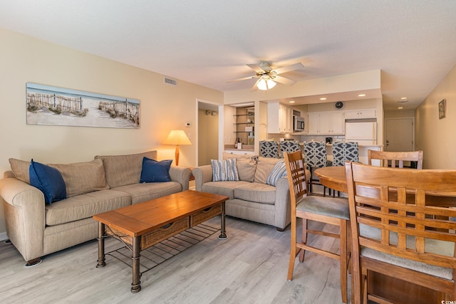 living room with ceiling fan and light hardwood / wood-style floors