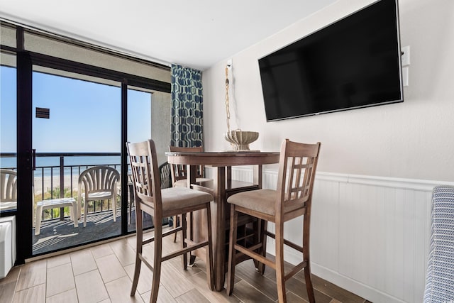 dining space with plenty of natural light, a water view, and light hardwood / wood-style flooring