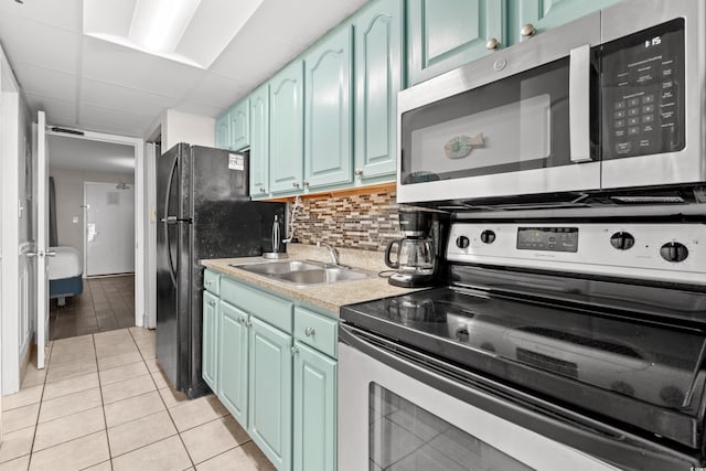 kitchen with a paneled ceiling, sink, decorative backsplash, light tile patterned flooring, and stainless steel appliances