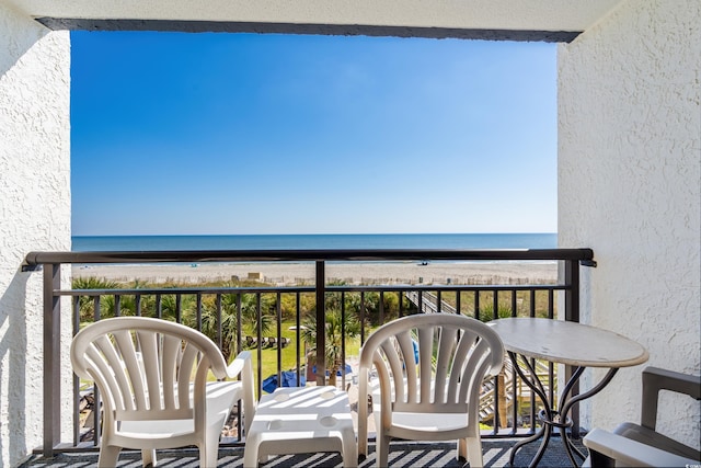 balcony featuring a water view and a view of the beach