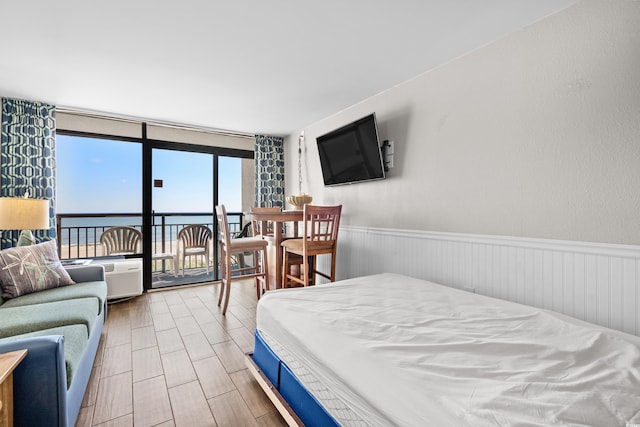 bedroom featuring hardwood / wood-style flooring and a water view