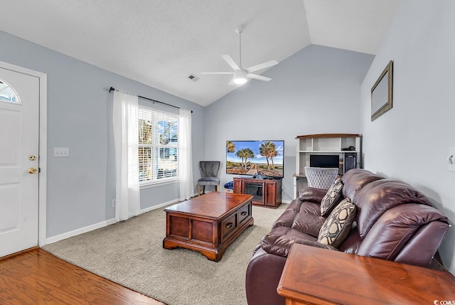 living room with ceiling fan, light hardwood / wood-style floors, and lofted ceiling