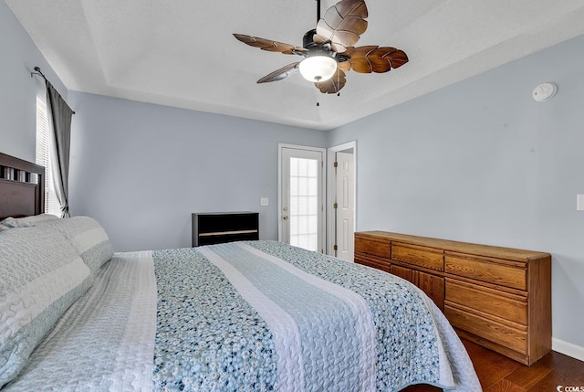 bedroom featuring a tray ceiling, ceiling fan, and dark hardwood / wood-style floors