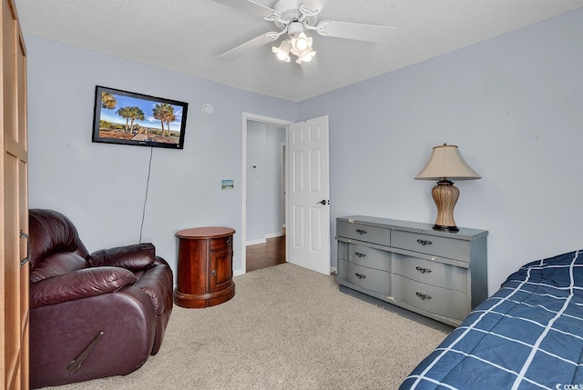 carpeted bedroom with a textured ceiling and ceiling fan