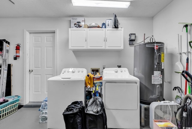 laundry room featuring washing machine and clothes dryer, water heater, cabinets, and a textured ceiling