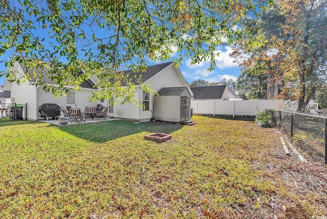 view of yard featuring a storage shed, a patio, and an outdoor fire pit