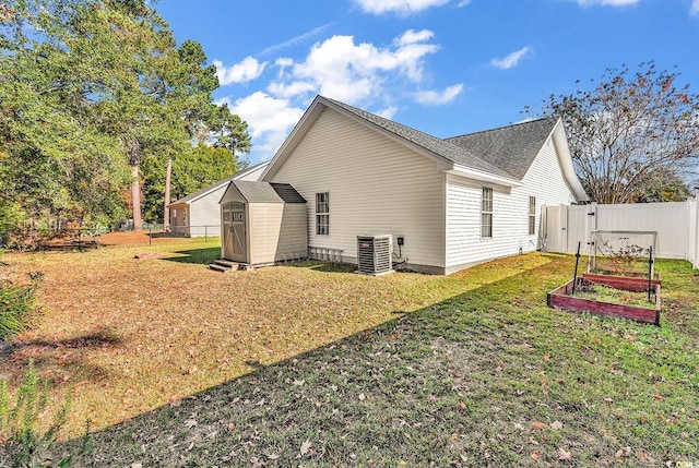 view of home's exterior with central AC unit, a shed, and a lawn