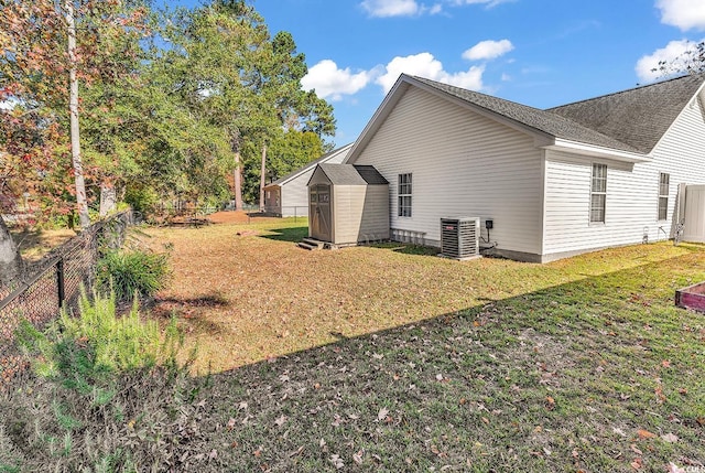 view of side of property featuring a storage unit, central air condition unit, and a yard