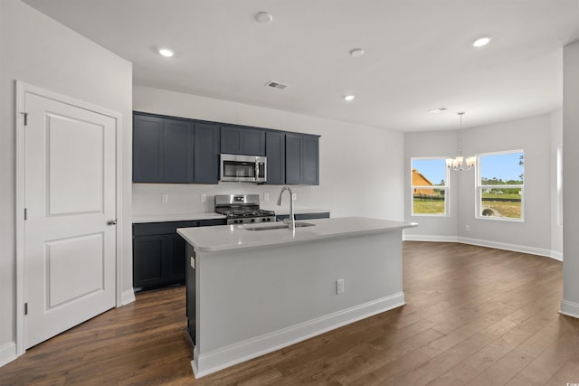 kitchen with a sink, appliances with stainless steel finishes, visible vents, dark wood-style floors, and an inviting chandelier
