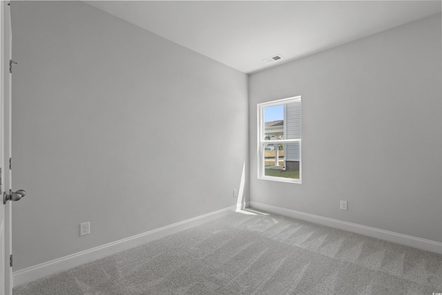 carpeted spare room with baseboards and visible vents