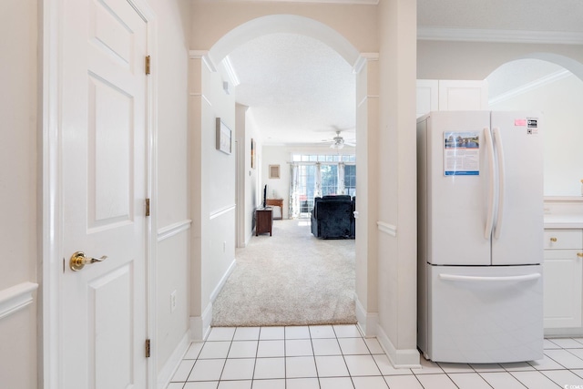 corridor with crown molding and light carpet