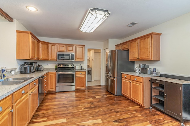 kitchen featuring dark hardwood / wood-style floors, sink, and appliances with stainless steel finishes