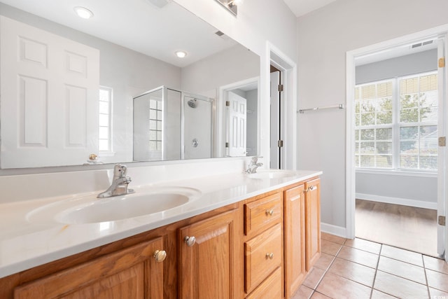 bathroom featuring tile patterned flooring, vanity, and an enclosed shower