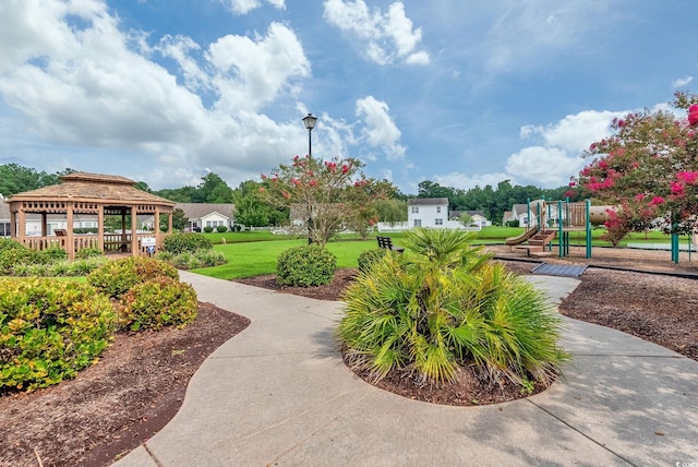 view of property's community featuring a playground and a lawn