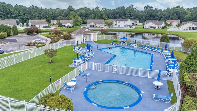 view of pool featuring a lawn and a water view