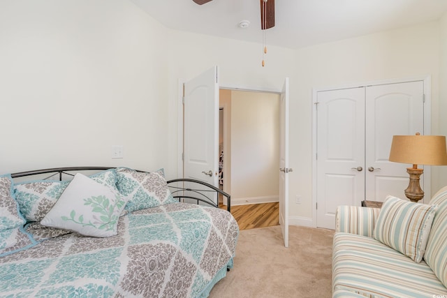 carpeted bedroom featuring ceiling fan and a closet