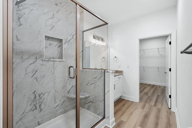 bathroom featuring hardwood / wood-style floors, vanity, and an enclosed shower