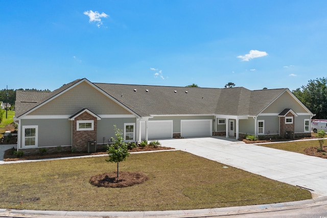 ranch-style home featuring central AC, a front yard, and a garage