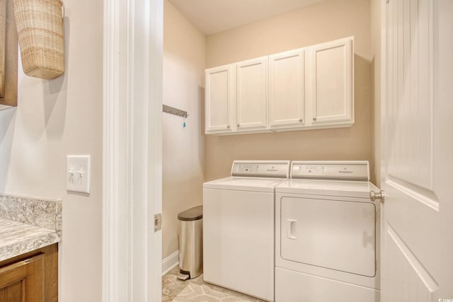 laundry room featuring cabinets, independent washer and dryer, and light tile patterned floors