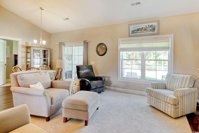 living room with wood-type flooring, vaulted ceiling, and a notable chandelier