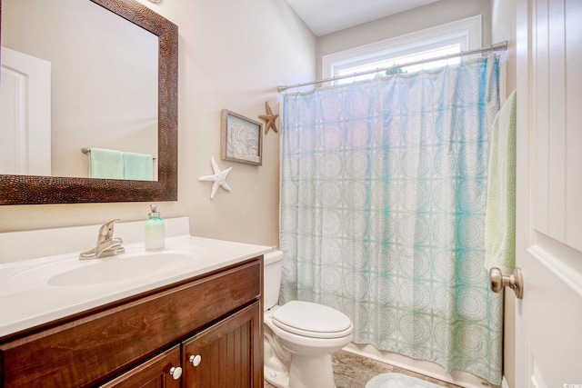 bathroom featuring walk in shower, vanity, and toilet