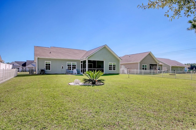 back of house with a lawn and a sunroom