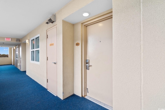 corridor featuring dark colored carpet