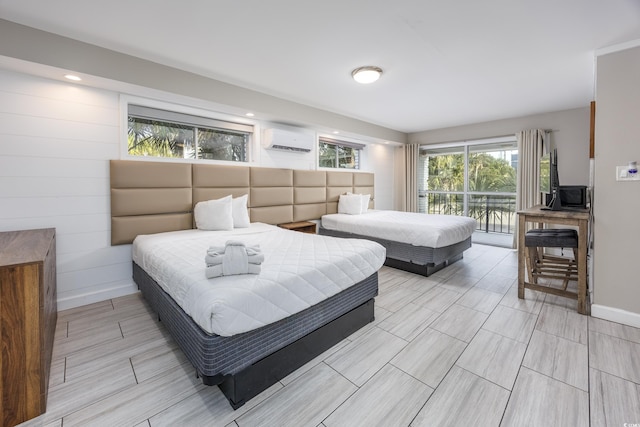 bedroom with access to outside and an AC wall unit