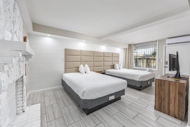 bedroom with a fireplace and an AC wall unit