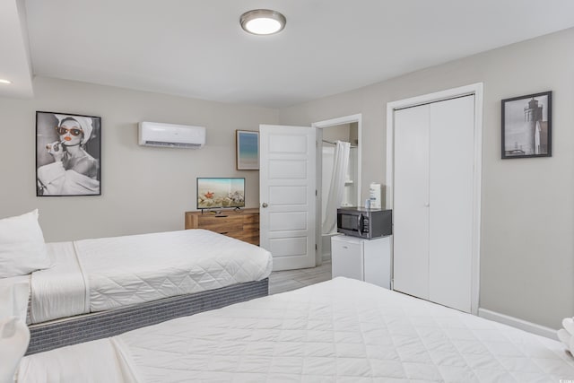 bedroom featuring an AC wall unit and a closet