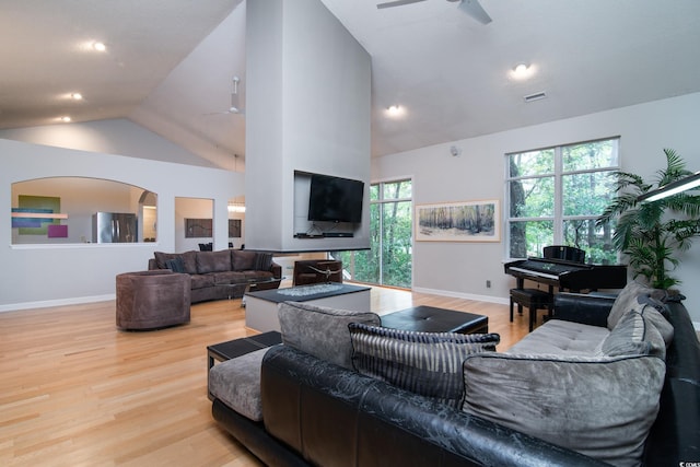 living room with light wood-type flooring, high vaulted ceiling, and ceiling fan