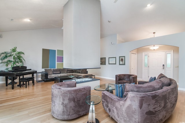 living room with high vaulted ceiling and light hardwood / wood-style flooring