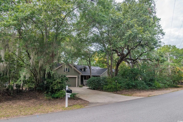 view of property hidden behind natural elements with a garage