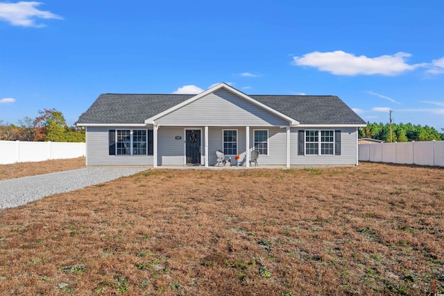 ranch-style home featuring covered porch and a front yard