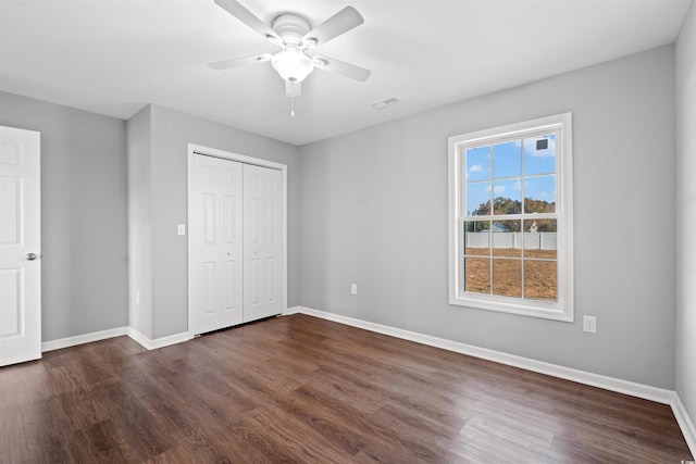 unfurnished bedroom featuring a closet, dark wood-type flooring, and ceiling fan