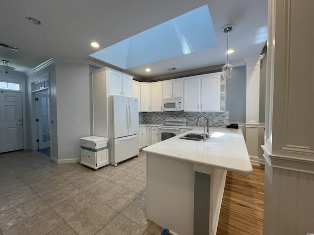 kitchen with open shelves, a sink, white appliances, a peninsula, and ornamental molding