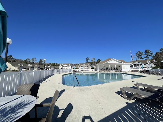 pool with fence, a residential view, and a patio area