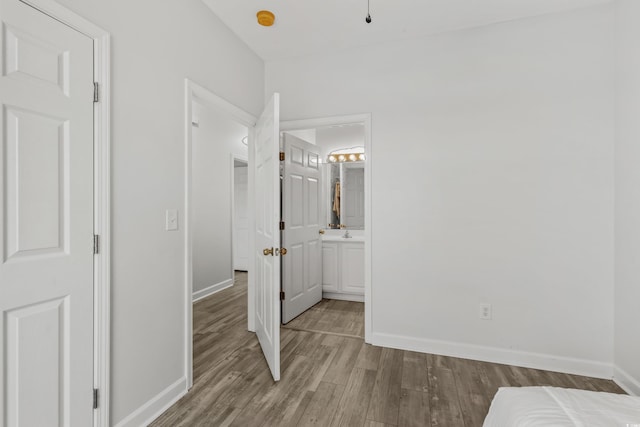 unfurnished bedroom with sink, light hardwood / wood-style flooring, and ensuite bath