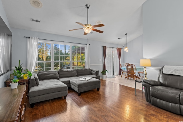 living room with ceiling fan, wood-type flooring, and vaulted ceiling