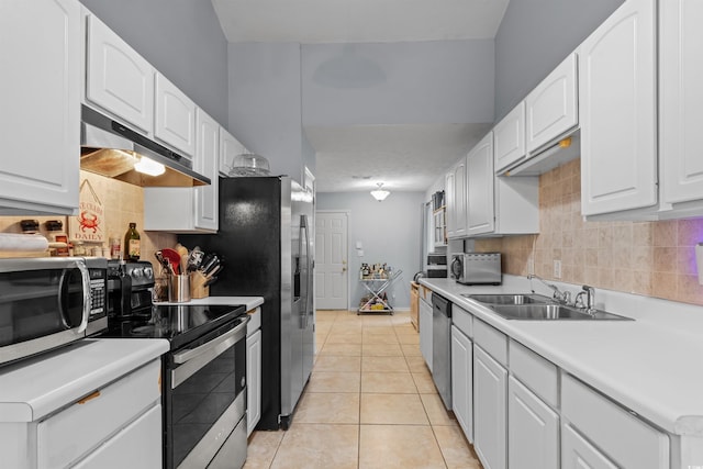 kitchen with tasteful backsplash, stainless steel appliances, sink, light tile patterned floors, and white cabinets