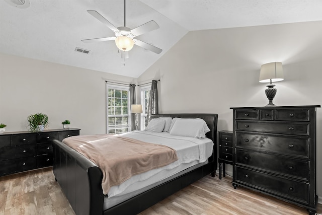 bedroom with ceiling fan, light hardwood / wood-style flooring, and lofted ceiling