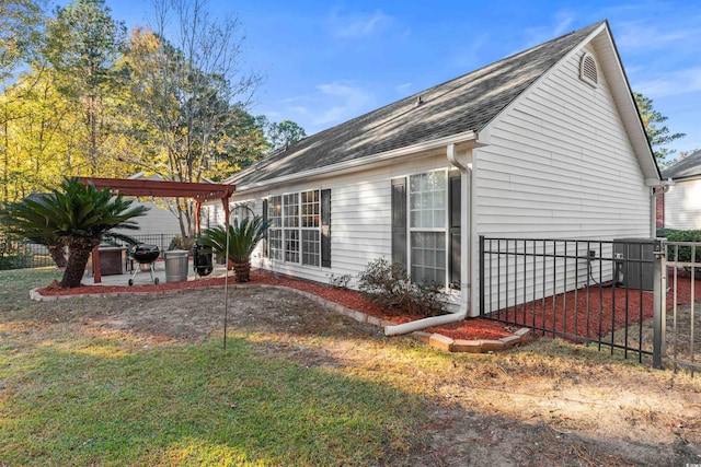 view of side of home featuring a pergola, a patio area, and a lawn