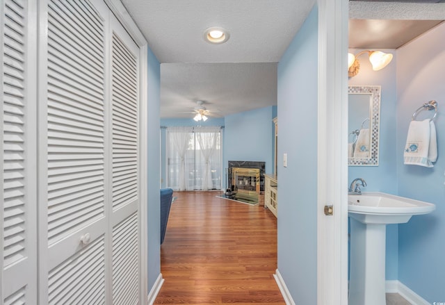 hall featuring hardwood / wood-style floors, sink, and a textured ceiling