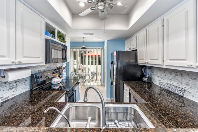 kitchen featuring tasteful backsplash, white cabinetry, black appliances, and decorative light fixtures