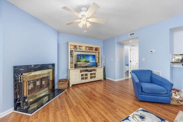 86 Shadow Moss Pl Unit 86, North Myrtle Beach, SC 29582 - living room featuring a high end fireplace, wood finished floors, a ceiling fan, a textured ceiling, and baseboards