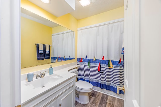 bathroom with vanity, wood-type flooring, a textured ceiling, and toilet