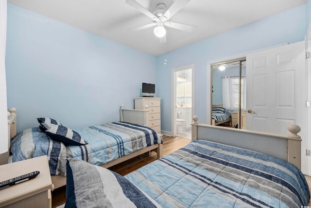 bedroom featuring hardwood / wood-style floors, ceiling fan, ensuite bath, and a closet