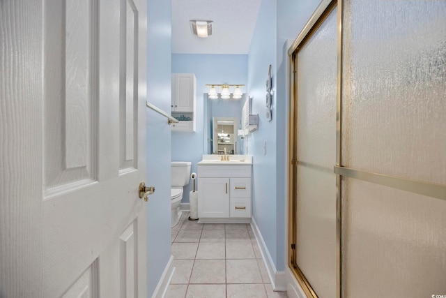 bathroom with toilet, vanity, tile patterned floors, and a shower with door